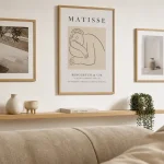 Décorer mur blanc : cadres en chêne clair, étagère flottante et lumière douce.